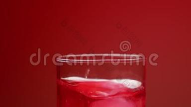<strong>冰块</strong>落在杯子里，用红色苏打水，溅起水花和气泡。 鸡尾酒吸管<strong>搅拌</strong>。 慢动作